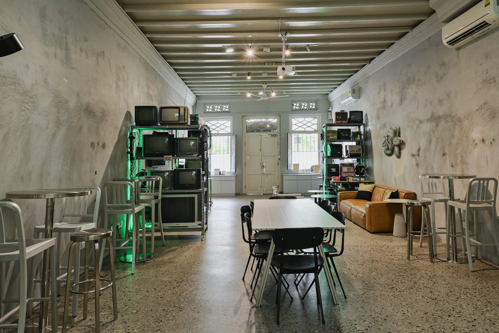 Existing common room at Figment Club House, with tables, seating and art